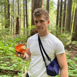 person in white shirt holding a mushroom